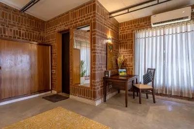 a brick room with a desk and a chair at amã Stays & Trails - Highland Breeze , Coimbatore in Coimbatore