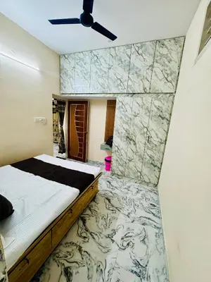 a bedroom with a bed and a marble wall at Flats in city center, next to NEXUS MALL in Mysore