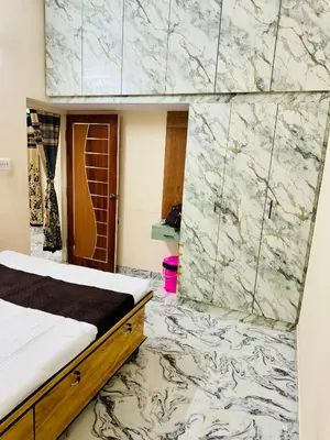 a bedroom with a bed and a marble wall at Flats in city center, next to NEXUS MALL in Mysore
