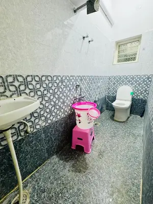 a bathroom with a pink bucket and a sink at Flats in city center, next to NEXUS MALL in Mysore