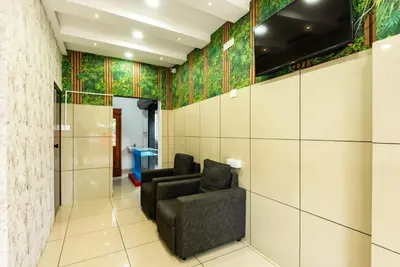 a room with two chairs and a wall with tiles at Oxe residency in Kozhikode