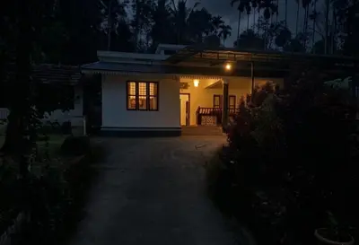 a small house at night with the lights on at Villa 9 degrees north in Sultan Bathery