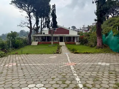a house with a stone driveway in front of it at NILGIRIS Inn in Kotagiri
