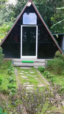 a doghouse with a window in a yard at Manna Homestay coorg in Kushālnagar