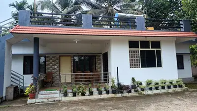 a small white house with a balcony at Manna Homestay coorg in Kushālnagar
