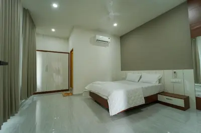 a bedroom with a white bed and a large window at SK Premium Residency in Edakkara