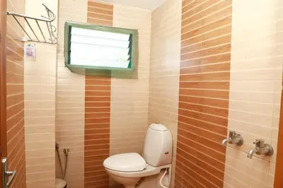 a bathroom with a toilet and a window at Rainbow Homestay Wayanad in Kalpetta