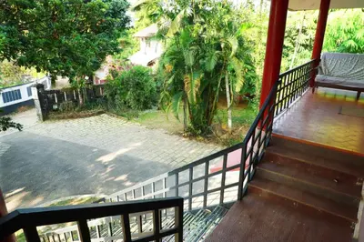 a balcony of a house with a wooden railing at Rainbow Homestay Wayanad in Kalpetta