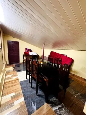 a room with two beds and a table in it at Edwin and Edrin Service Villa in Wayanad