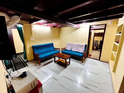 a living room with two blue couches and a table at Edwin and Edrin Service Villa in Wayanad