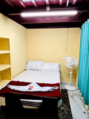 a small bedroom with a bed with a fan at Edwin and Edrin Service Villa in Wayanad