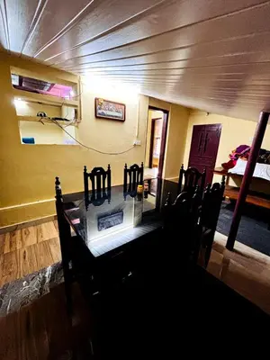 a dining room with a table and chairs in a room at Edwin and Edrin Service Villa in Wayanad