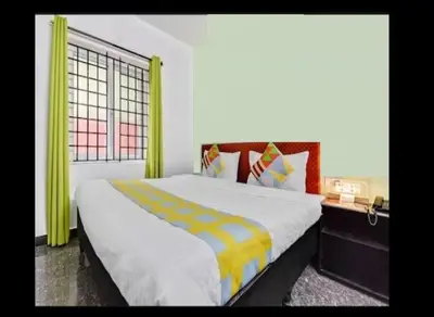 a bedroom with a large bed with yellow curtains at LIMRA INN RESIDENCY cottage in Ooty