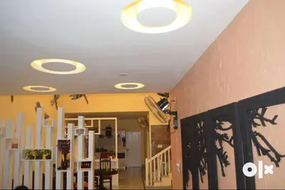 a living room with a ceiling with lights on it at Charis Villa and Guest house 5bed 4bath in kunnamkulam in Kunnamkulam