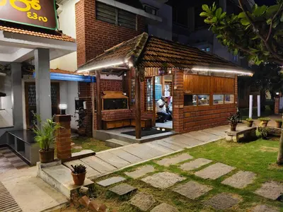a small building with a grill in a courtyard at The Palmyrah Tenements in Mysore