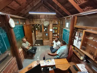 a group of men sitting in a room at The Palmyrah Tenements in Mysore