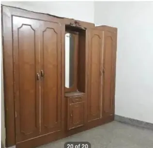 a wooden cabinet with a mirror in a room at PG For Men in Mysore