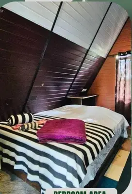 a bed with a striped blanket on it in a room at Happy Feet Wayanad in Vaduvanchal