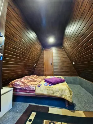 a bed in a room with a wooden wall at Happy Feet Wayanad in Vaduvanchal