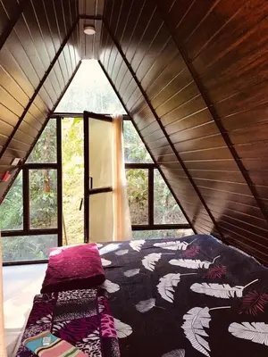 a bed in a room with a large window at Happy Feet Wayanad in Vaduvanchal