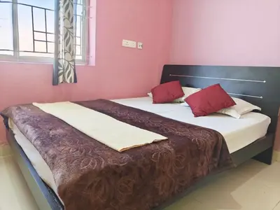 a bedroom with two beds with red walls at Greenland 2bed room hall villa in Ooty