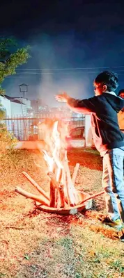 two people standing around a fire in a field at Greenland 2bed room hall villa in Ooty