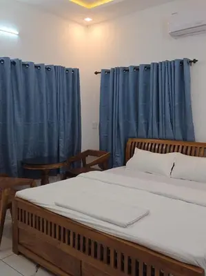 a bedroom with a large bed with blue curtains at The Paul Residence