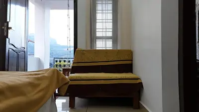 a chair sitting in a room with a window at Couples Nest in Kottakamboor