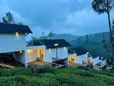 a row of houses on a hill with lights at Feliz by slowlane stays in Kotagiri