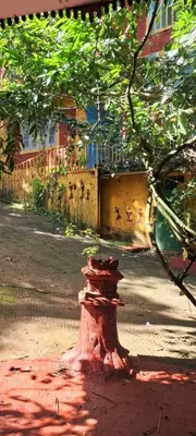 a fire hydrant sitting on the ground under a tree at Tapovan Fruitopia in Sultan Bathery