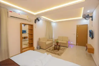 a bedroom with a bed and a chair and a mirror at Munderi Green Mounts - Family Rooms with Swimming Pool in Kalpetta