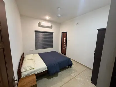 a bedroom with a bed and a window in it at Satori Stays - KMA Apartments in Kozhikode