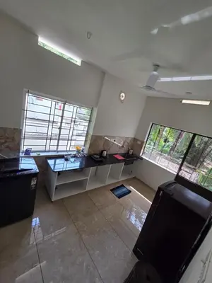 a living room with two large windows and a television at Satori Stays - KMA Apartments in Kozhikode