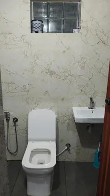 a bathroom with a toilet and a sink at Satori Stays - KMA Apartments in Kozhikode