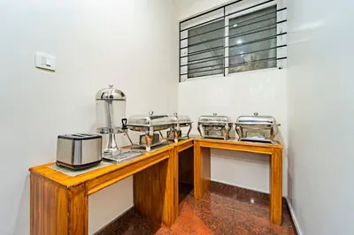 a kitchen with a wooden table with four dishes at Treebo Lumino Crown, 850 Meters From Ooty Lake in Ooty