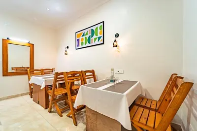 a dining room with a table and chairs at Treebo Lumino Crown, 850 Meters From Ooty Lake in Ooty