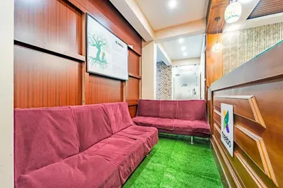 a waiting room with red couch and green carpet at Treebo Lumino Crown, 850 Meters From Ooty Lake in Ooty