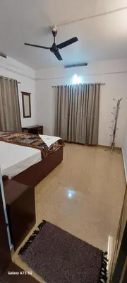 a bedroom with two beds and a ceiling fan at Hill valley farm resort in Viripara