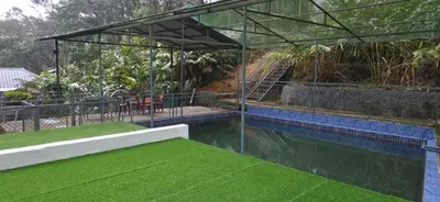 a house with a swimming pool with green grass at Hill valley farm resort in Viripara