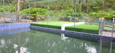 a tennis court in the middle of a pool of water at Hill valley farm resort in Viripara