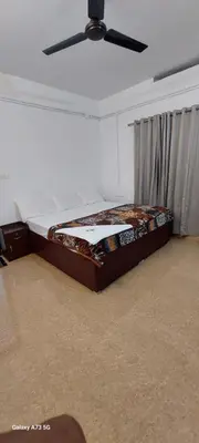 a bed in a room with a ceiling fan at Hill valley farm resort in Viripara