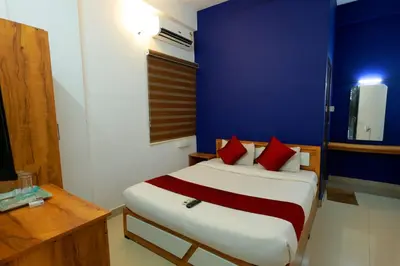 a bedroom with a bed with red pillows and a blue wall at Calicut residency in Kozhikode