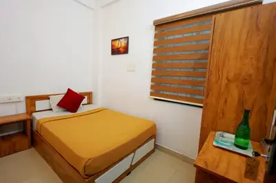 a small room with a bed and a window at Calicut residency in Kozhikode