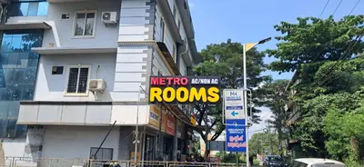 a sign on the side of a building that reads metro orange rooms at Metro Residency in Perintalmanna