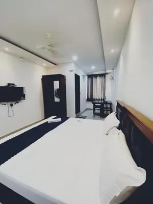 a bedroom with a large white bed in a room at Metro Residency in Perintalmanna