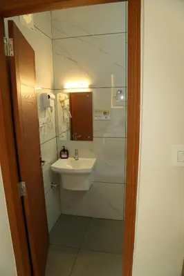 a bathroom with a sink and a mirror at Cloud9 Airport Hotel in Nedumbassery