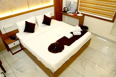 a bed with white sheets and pillows in a room at Cloud9 Airport Hotel in Nedumbassery