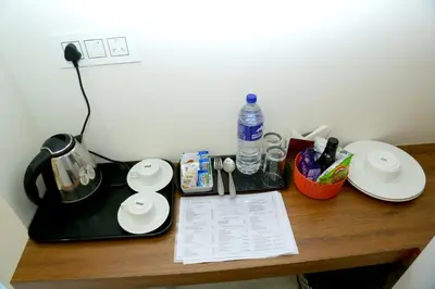 a desk with a tea kettle and plates on it at Cloud9 Airport Hotel in Nedumbassery