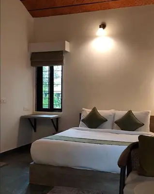 a bedroom with a large bed and a window at Trisara Boutique Stay in Mysore