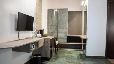 a hotel room with a television and a bathroom at Trisara Boutique Stay in Mysore